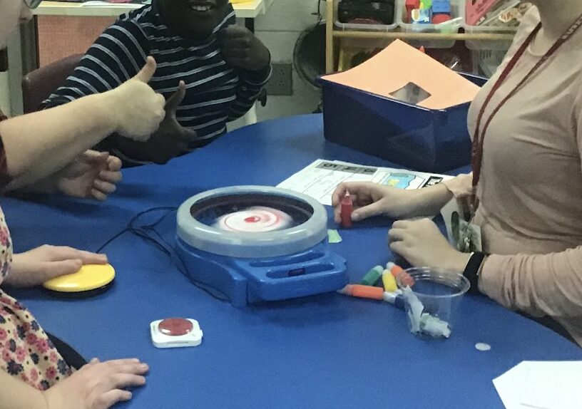 students using a switch attached to a PowerLink to operate a spinner to make splatter paint spin art