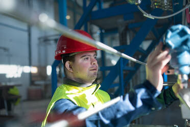 A young man with disabilities operating machinery in a factory job placement