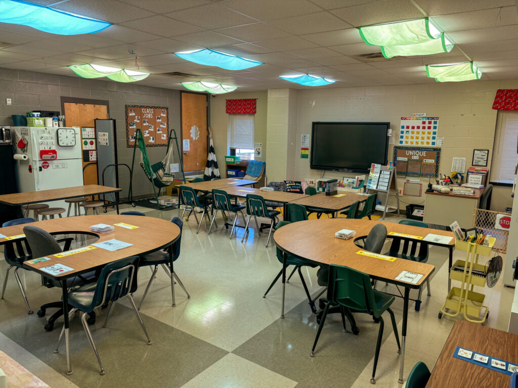 view of the entire classroom including a whole group area and tables for smaller groups