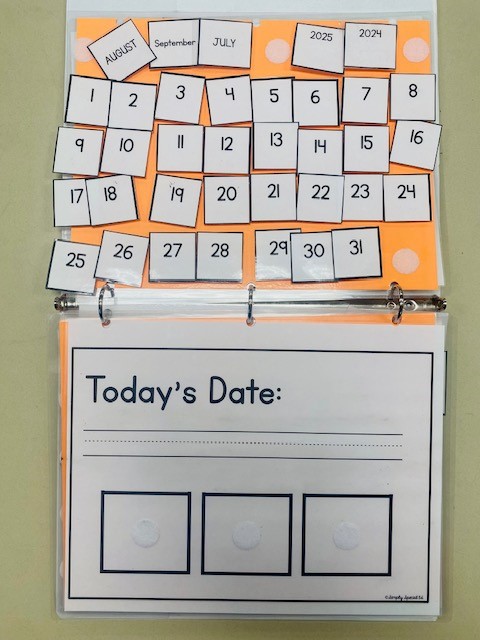 A binder with a page showing "Today's Date" and calendar number options.