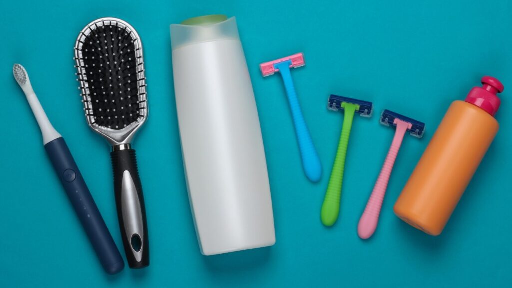 hygiene tools on a teal background including toothbrush, hair brush, soaps, and shaving tools