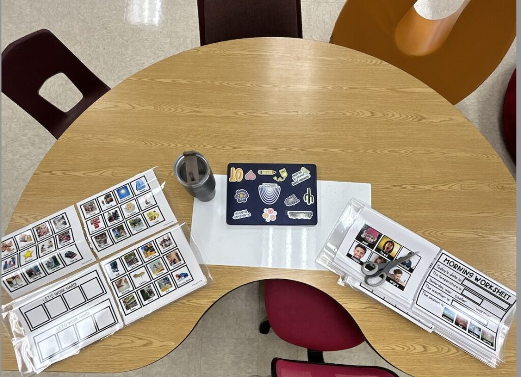 kidney table used as desk with laptop with OT stickers, Stanley cup and lamination to cut SSE resources