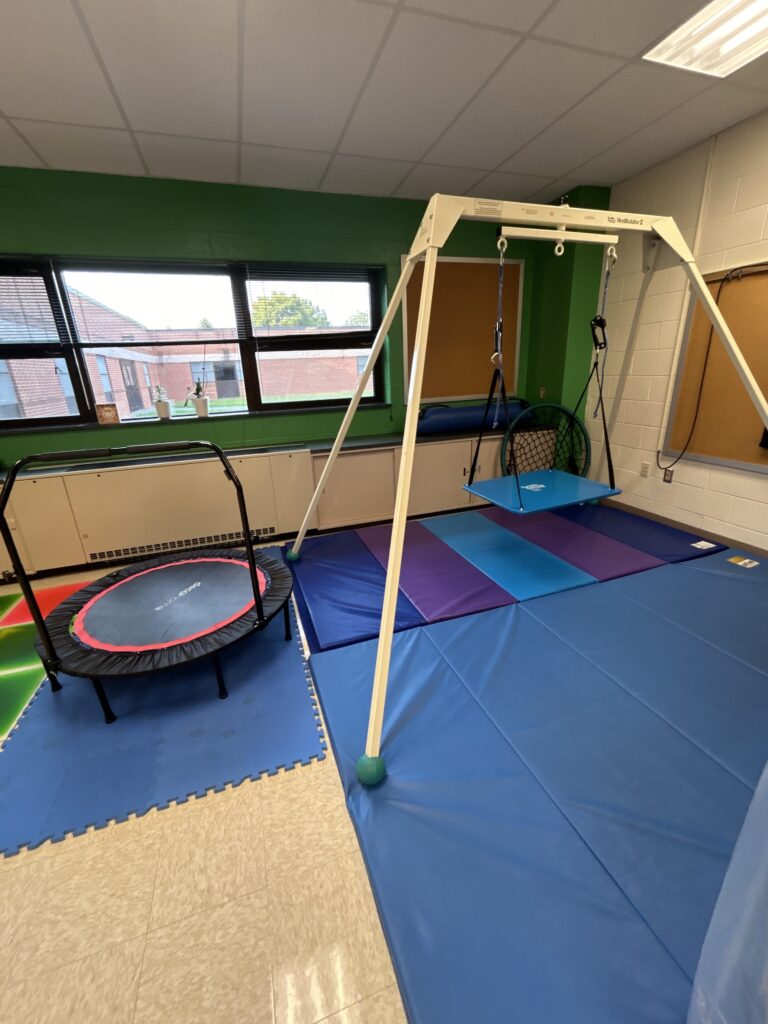 platform swing on frame and trampoline on mats in the sensory room