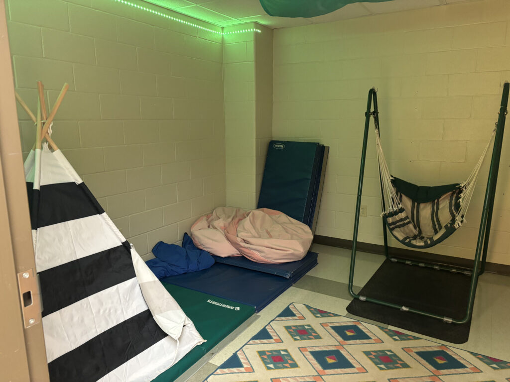 classroom sensory space with a swing, beanbag chairs, a tent, and special lighting