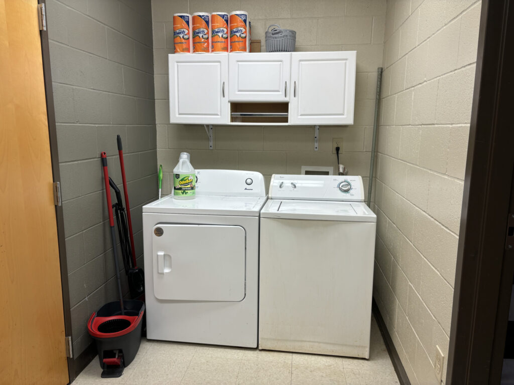 A washer and dryer are in the classroom with cleaning supplies to be utilized for life skills