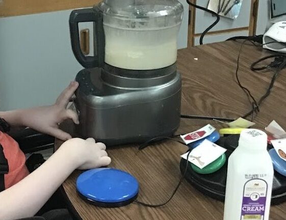 student using a switch adapted blender to make food in the classroom
