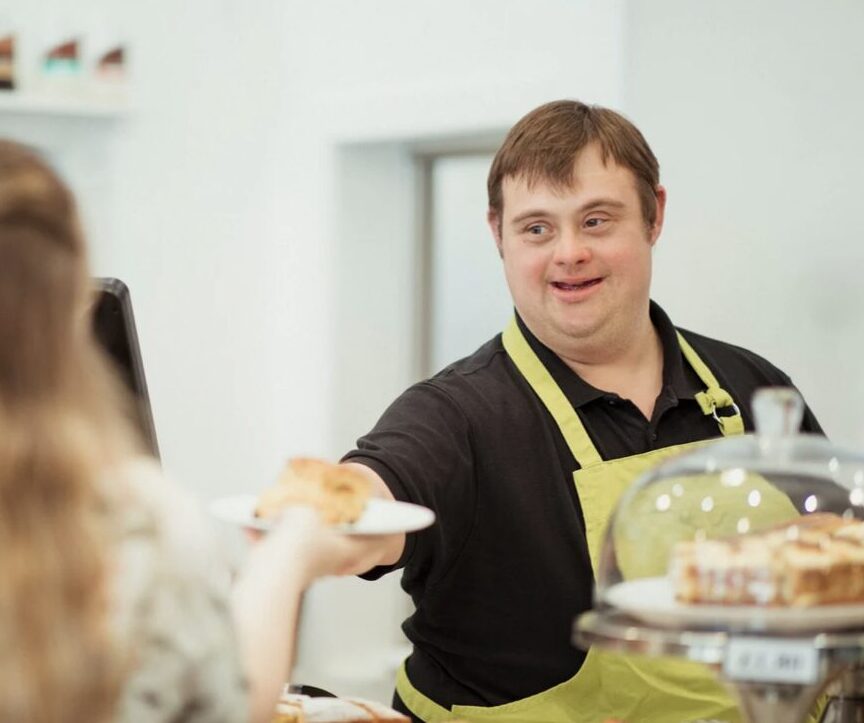 person with Down Syndrome serving a customer at a cafe