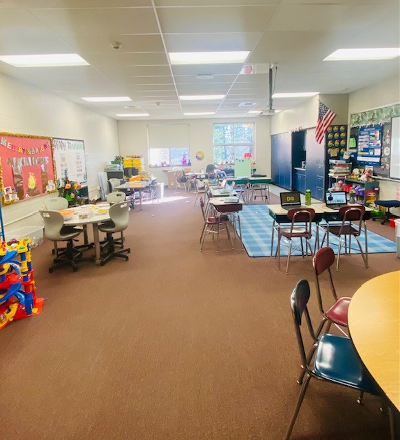 A view of a classroom is shown, with students desks and tables visible.