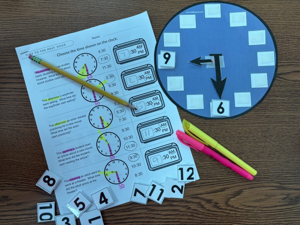 a visual clock with velcro pieces, pencils, and highlighters sit near a time worksheet