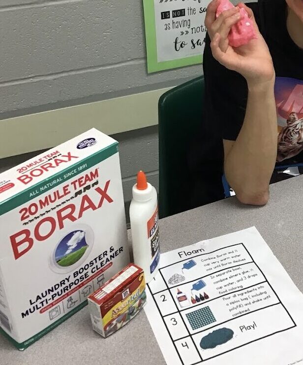 student holding up DIY putty they made with Borax following a visual recipe
