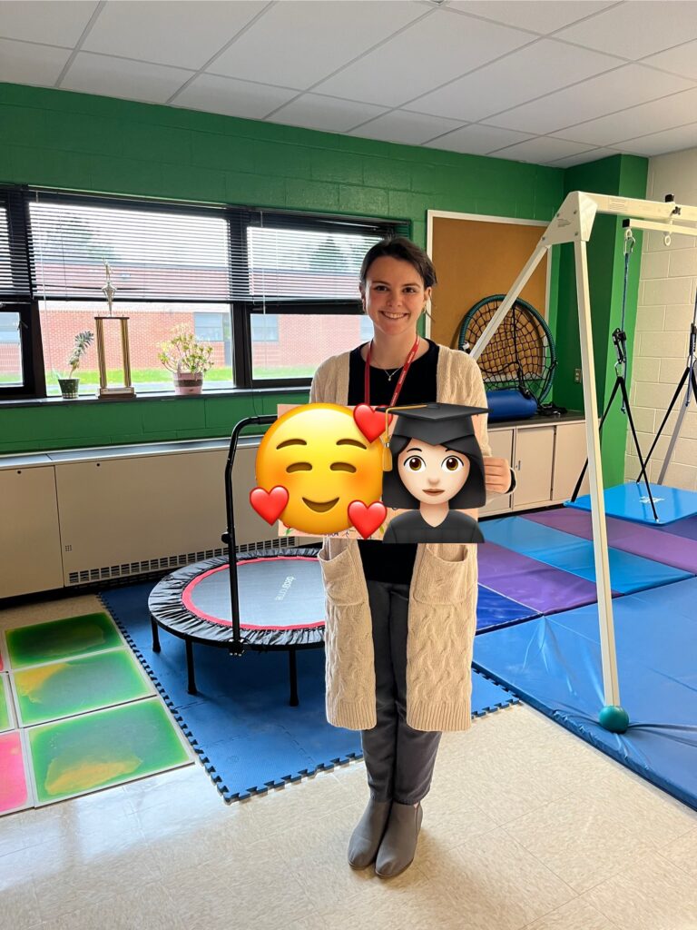 fieldwork student holding up a thank you card from the students in the sensory room on her last day