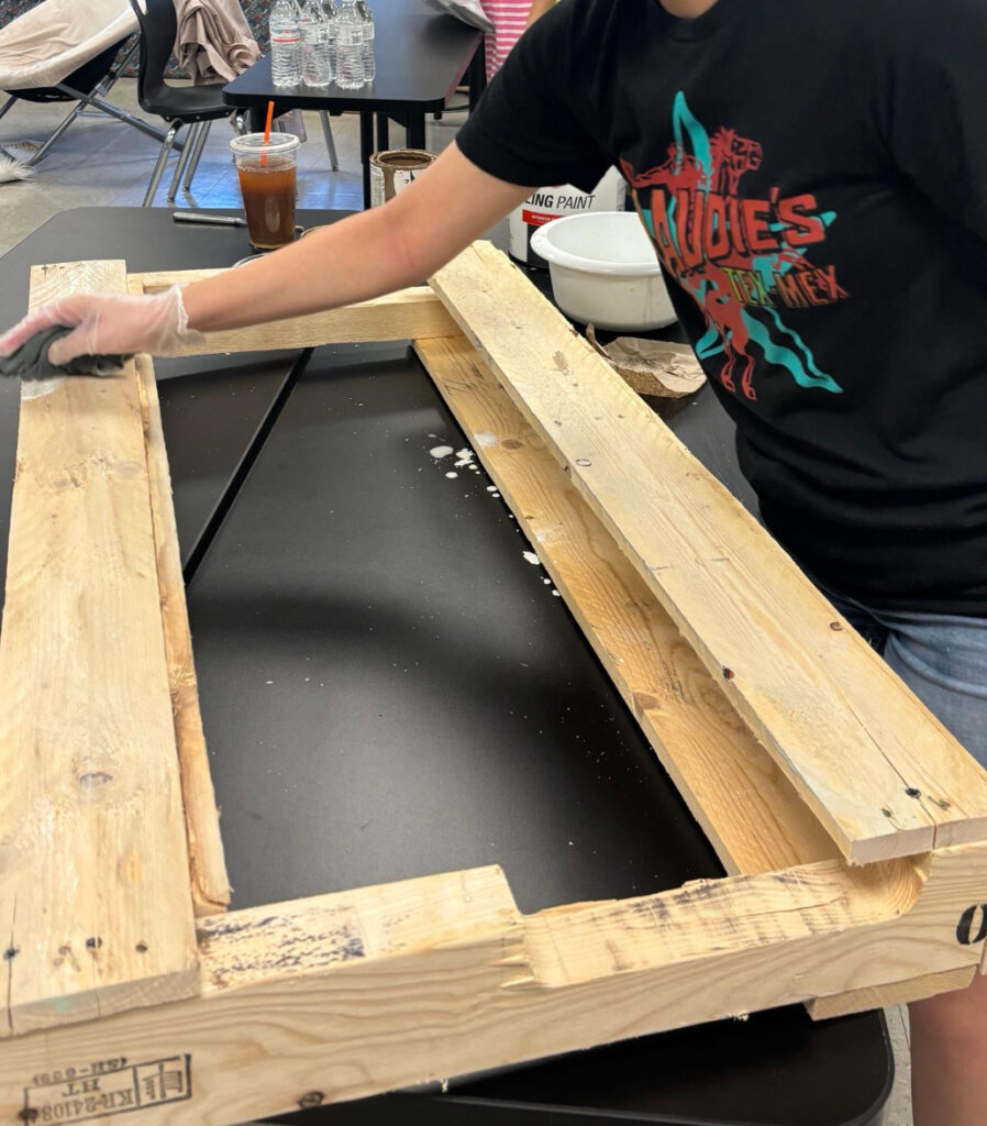 student sanding wood for a project to sell at the classroom bazaar