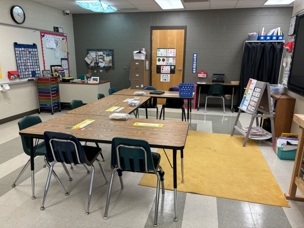 Whole classroom view with group table and easel