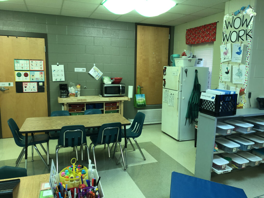 A shelf separates the classroom kitchen from other areas