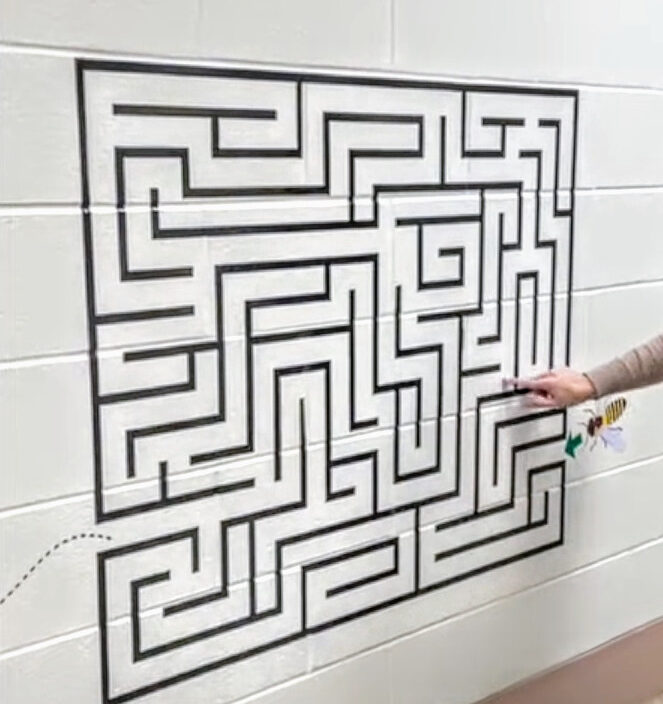 someone completing a maze on the wall as part of a sensory path that was funded via grants