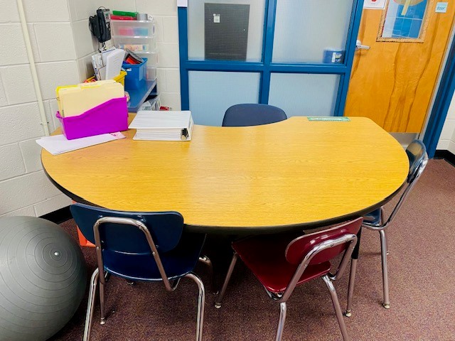 A wooden u-shaped table in a classroom