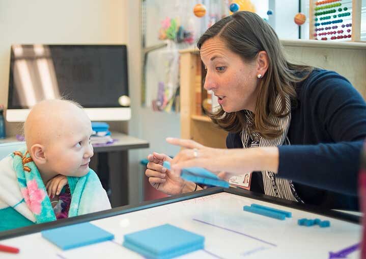 A teacher working on a math lesson with a child in a hospital 