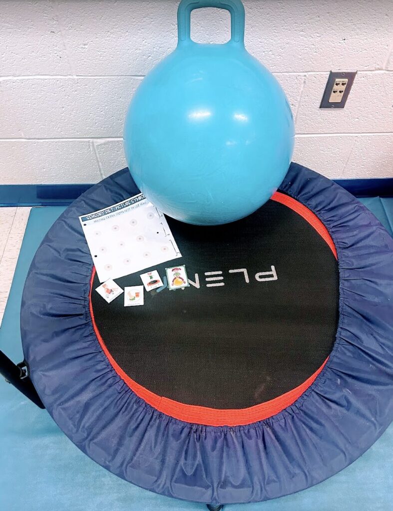 trampoline with a sensory schedule and a hoppy ball on it