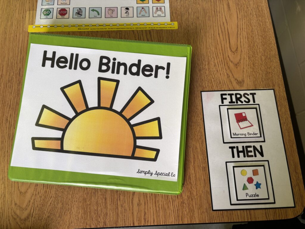 The Hello Binder is shown on a desktop next to a first/then board. Students use this resource for functional life skills practice.
