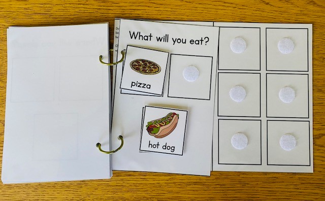 A comprehension apge of an adapted book that says "What will you eat?" and has picture choices of a hot dog and pizza.