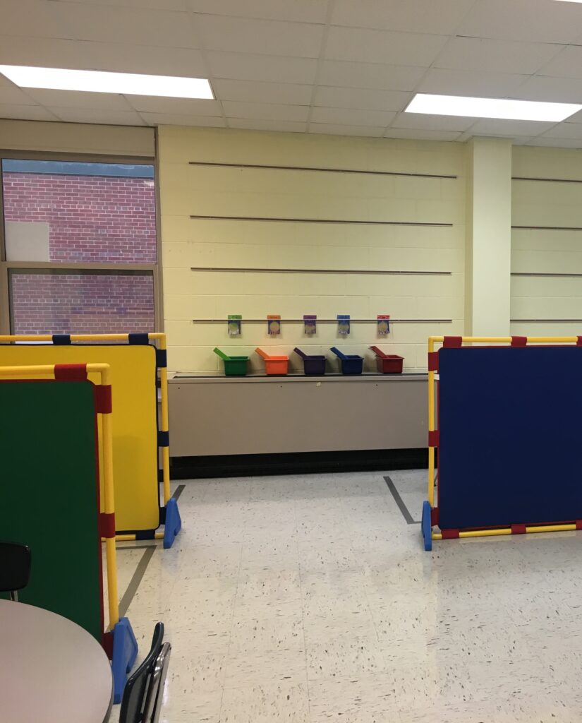 Color coded bins on a wall for students' arrival routine