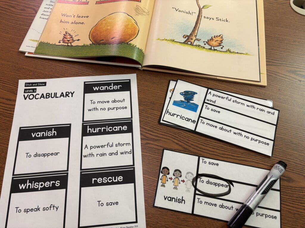 A book companion is paired with leveled vocabulary, and sits with vocabulary clip cards that are being used with a dry erase marker.