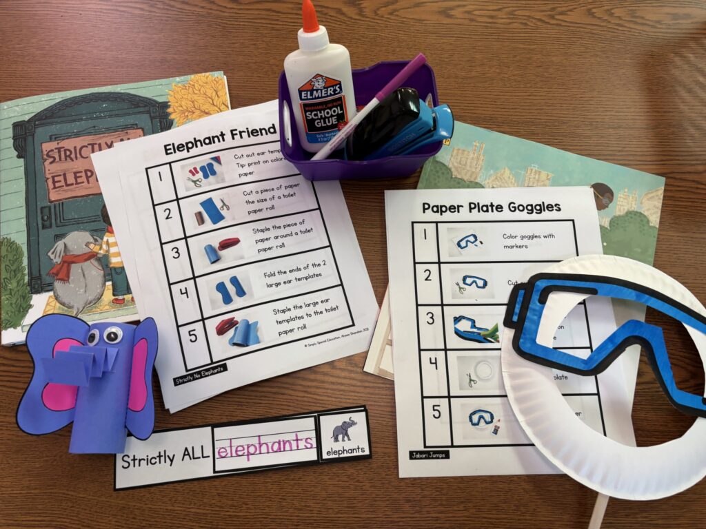 A toilet paper elephant craft and paper plate goggles craft are laid on a table next to the books they are paired with along with visual steps to complete each craft.