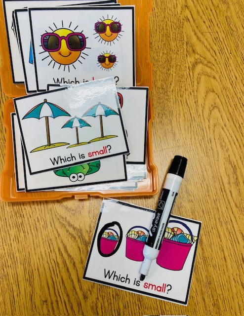Summer-themed task box cards are shown on a table, with a dry erase marker for circling the answer