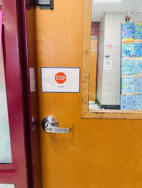 A classroom door with a stop sign label