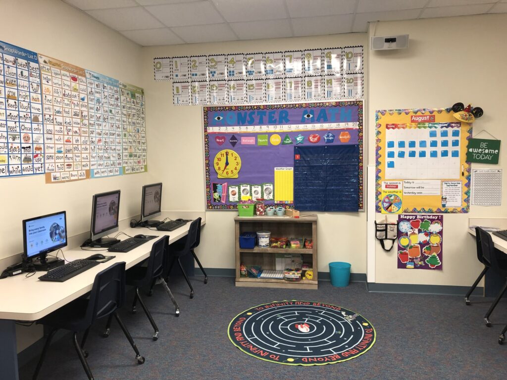 A math bulletin board is between two rows of computers in a computer station for math center