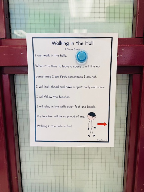 A "Walking in the Hall" social story is shown hanging in a classroom