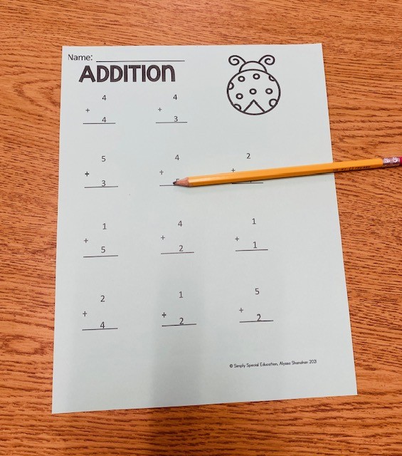 An addition worksheet with a pencil, on a table