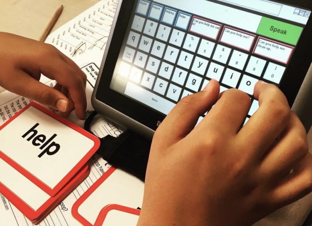 A student using an AAC device to spell the word "help"