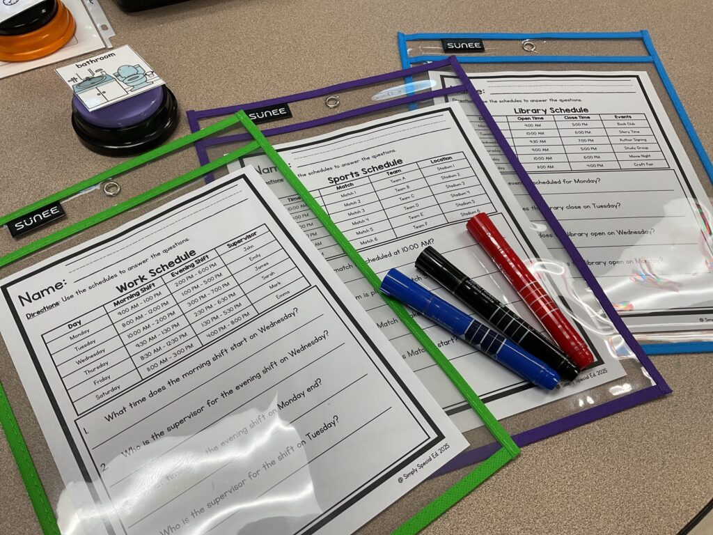 A reading schedules set of 3 worksheets lay on a tabletop in dry erase pockets with dry erase markers