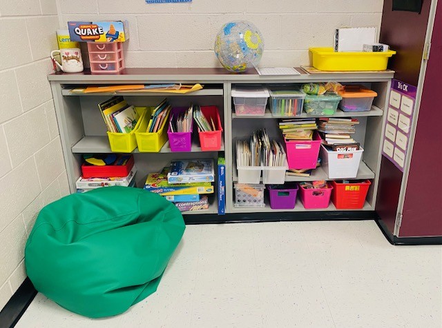 Shelves in a classroom that show bins of books and other materials