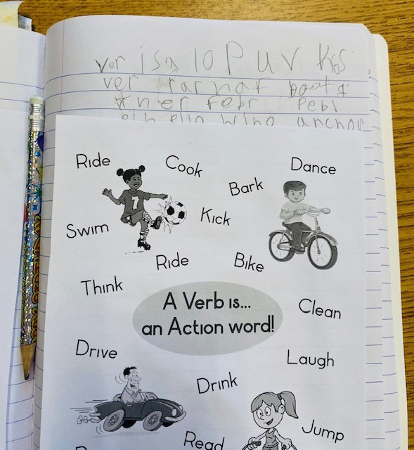 A student notebook with a page describing verbs